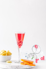 red non-alcoholic aperitif with chips and slices of orange on a white background 