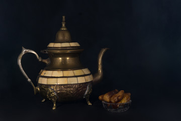 Vintage kettle on black background with dates.