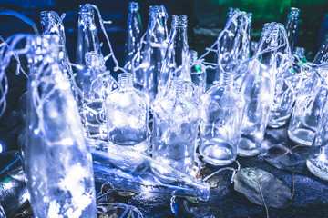 White LED light in many clear glass bottles placed on the floor. Concept Decorated from unused items.