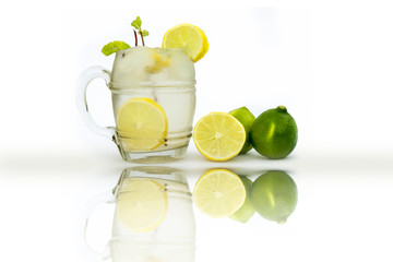 Virgin Mint Julep isolated on white in a transparent glass isolated on white with fresh lemons and mint or mentha leaves.