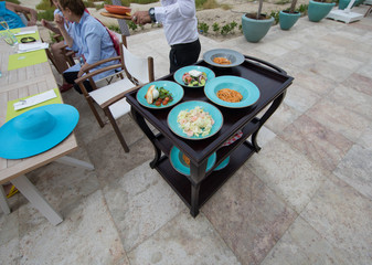 waiter with food tray on a trolley in a restaurant