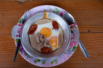 Fried panned egg with fermented pork sausage, chinese sausages and minced pork, served in the hot pan.