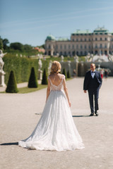 Obraz premium Beautiful young bride with her handsome groom walking in palace Belvedere