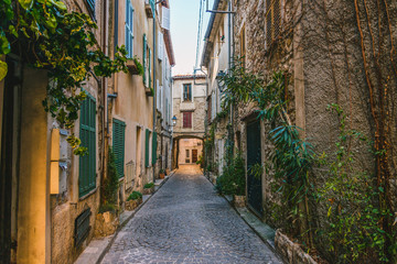Little alley in the medieval village of Antibes in a sunny winter day - obrazy, fototapety, plakaty