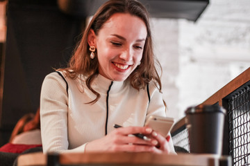 Portrait of a pretty young business lady working in a cafe. Papers, telephone conversations, laptop and coffee in the coworking area