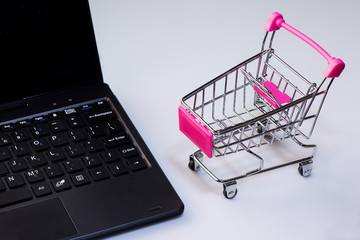 Shopping service on The online web. offers home delivery. Empty shopping cart on a laptop keyboard
