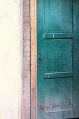 Green wooden door and a yellow wall background (Ari Atoll, Maldives)
