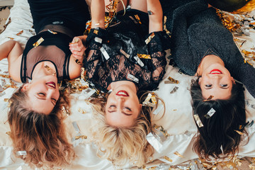 Women hangout joy. Great time together. Elated young females lying on bed upside down. Bachelorette...