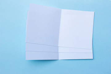 Blank portrait mock-up paper. brochure magazine isolated on blue, changeable background / white paper isolated on light blue paper.