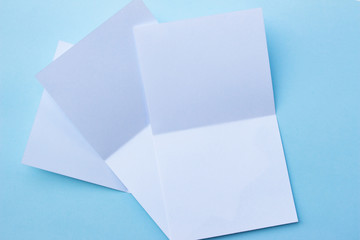 Blank portrait mock-up paper. brochure magazine isolated on blue, changeable background / white paper isolated on light blue paper.