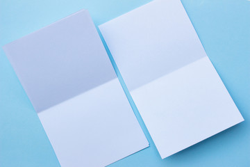 Blank portrait mock-up paper. brochure magazine isolated on blue, changeable background / white paper isolated on light blue paper.