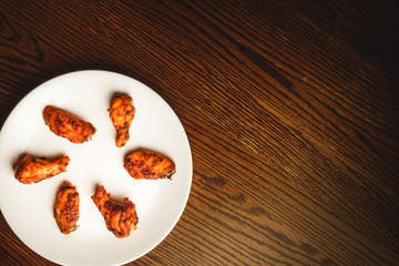 Chicken wings, beer, and dipping sauce on wooden table.