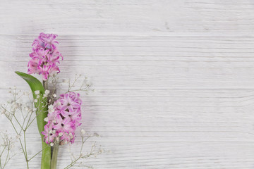 Abstract composition of fresh purple hyacinths on a white rustic wooden background. Pattern of different flowers