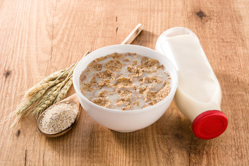 Oats milk and cereals on wooden table. 