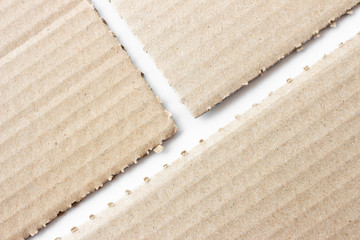 Brown corrugated texture paper torn on white background. rip of cardboard sheet used as a background .