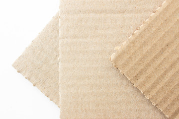 Brown corrugated texture paper torn on white background. rip of cardboard sheet used as a...
