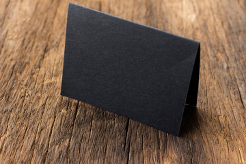 Blank portrait mock-up paper. brochure magazine isolated on brown wooden table, changeable background / Black paper isolated on wood