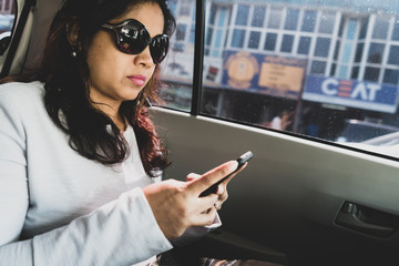 Woman with smart phone in a car