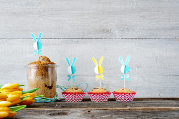 Osterhintergrund mit Kuchen, Muffins und Blumen