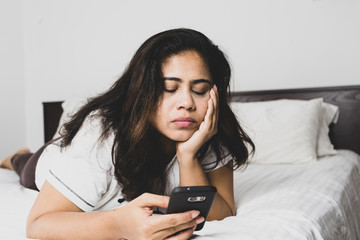 Woman using smartphone in bed