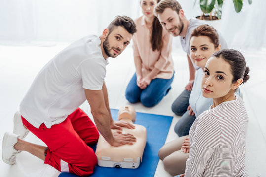 group of people with instructor looking at camera during first aid training