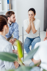 Obraz premium selective focus of woman covering face and crying during group therapy meeting