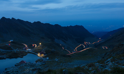 Fagaras mountains in Romania in the summer evening with Transfagarasan winding road with lights