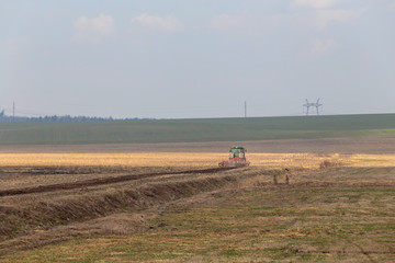 Fototapeta premium tractor plows the field in early spring for sowing crops. Agriculture of Belarus.