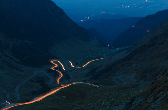 Fagaras mountains in Romania in the summer evening with Transfagarasan winding road with lights