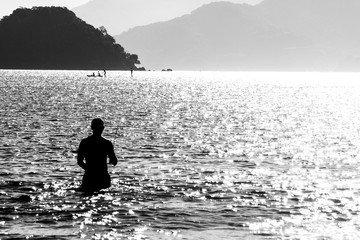 Silhouette of a man fishing on sea in Brazil