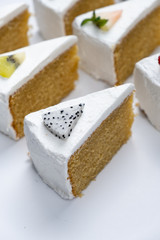 Delicious creamy minimal white cake with fruit on white background.