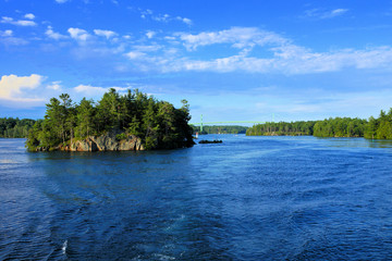 Peaceful landscape of the Thousand Islands during summer with bridge in background along Canadian...