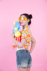 Happy girl holding a pink background water gun.