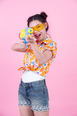 Happy girl holding a pink background water gun.