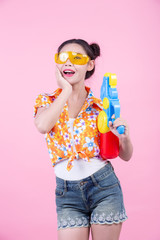 Happy girl holding a pink background water gun.