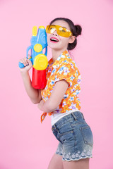Happy girl holding a pink background water gun.