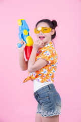 Happy girl holding a pink background water gun.