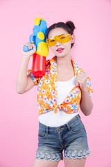 Happy girl holding a pink background water gun.