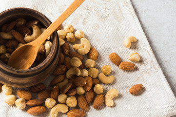 Different nuts - cashew nuts, almond, hazelnut into wooden bowl