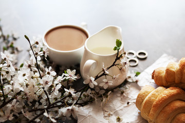 concept of morning breakfast. Fresh croissant and a cup of hot coffee with milk.