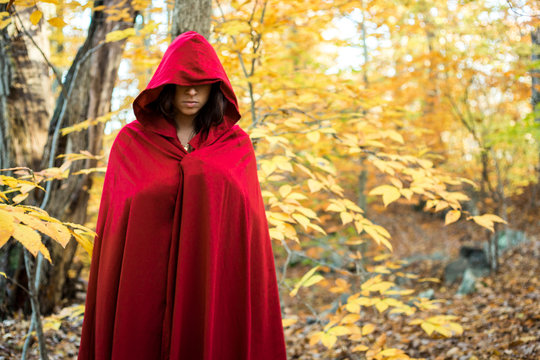woman in hooded red cloak in autumn