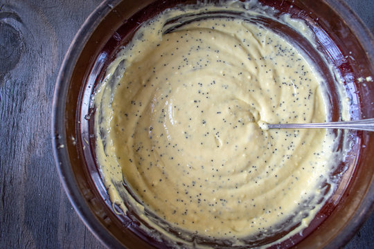 mixing bowl of lemon poppy seed cake mix with ingredients in flat lay