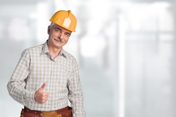 Young man in work uniform and yellow helmet