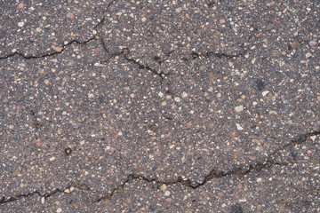Asphalt road surface with small cracks and damages