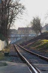 Railway tracks on the background of spring nature comes to life. Urban industrial landscape. Road to infinity.