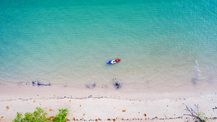 Aerial top view of kayaking around sea with shade emerald blue water and wave foam