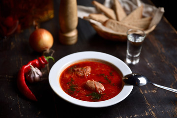 Homemade Russian, Ukrainian and Polish national soup - red borscht made of beetrot, vegetables and meat on a wooden background