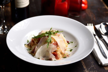 pasta with parmesan and prosciutto on a white plate