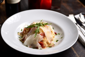 pasta with parmesan and prosciutto on a white plate