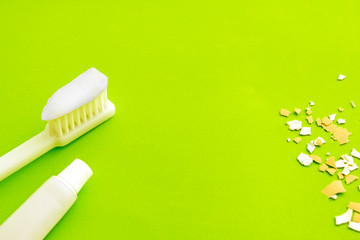 Brush and pasta, next to an egg shell on a green background. Dentistry concept. Oral hygiene. Care for the health of teeth and gums.